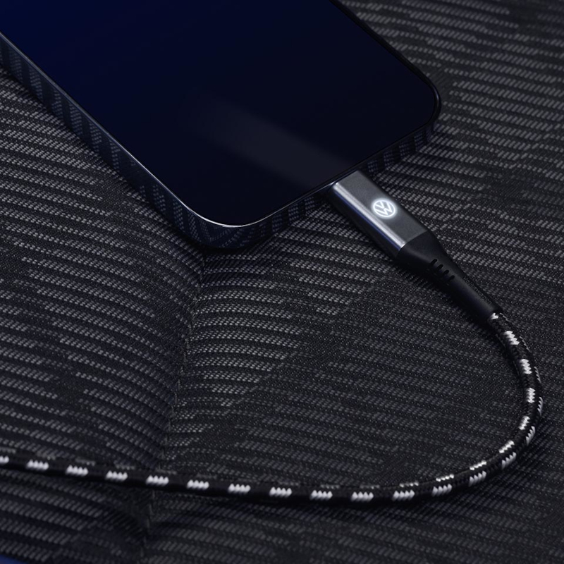 A person uses a smartphone that is networked with the digital functions of a VW vehicle.